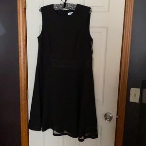 Black knee length dress with a sheer design around the bottom